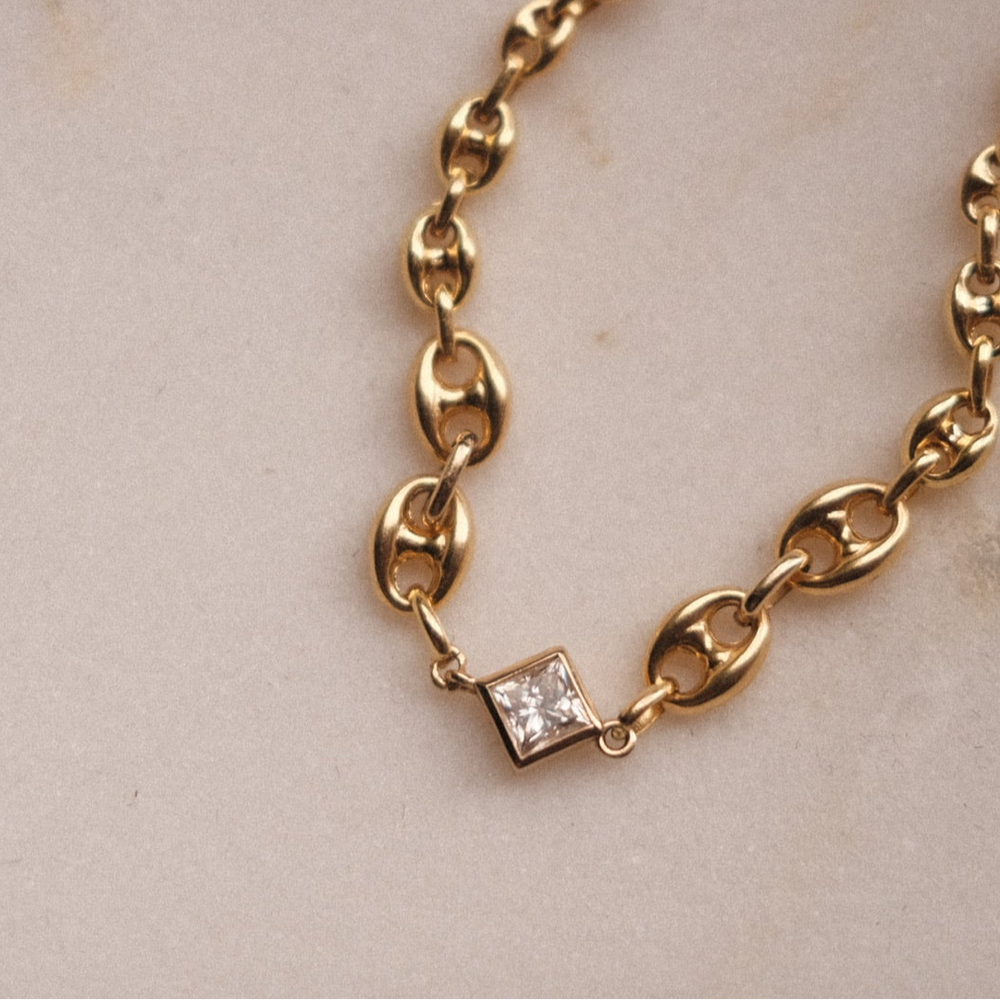 14K sold gold bracelet adorned with white gemstone.