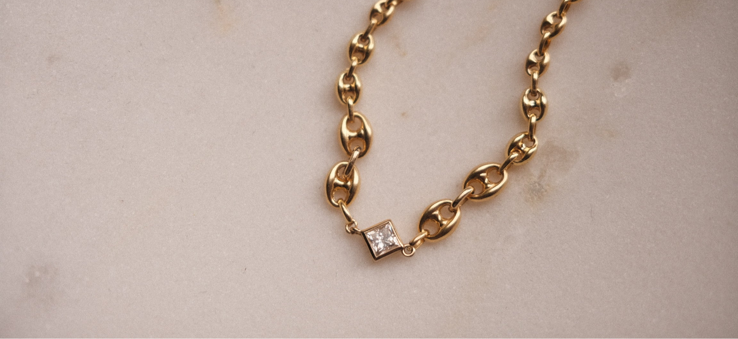 14K sold gold bracelet adorned with white gemstone.
