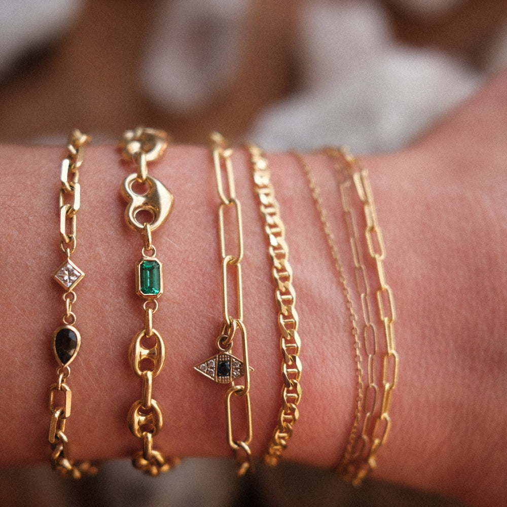 7 different types of 14K solid gold chain bracelets with and without gemstone modeling the various ways a love saro custom bracelet can come to life.