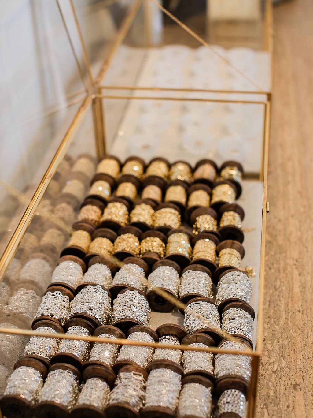 Sterling silver & 14K solid gold spools of chains inside an open glass and gold display case at the Melrose Place LA studio