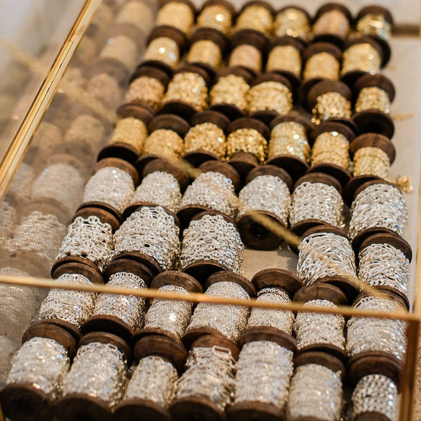 Sterling silver & 14K solid gold spools of chains inside an open glass and gold display case at the Melrose Place LA studio