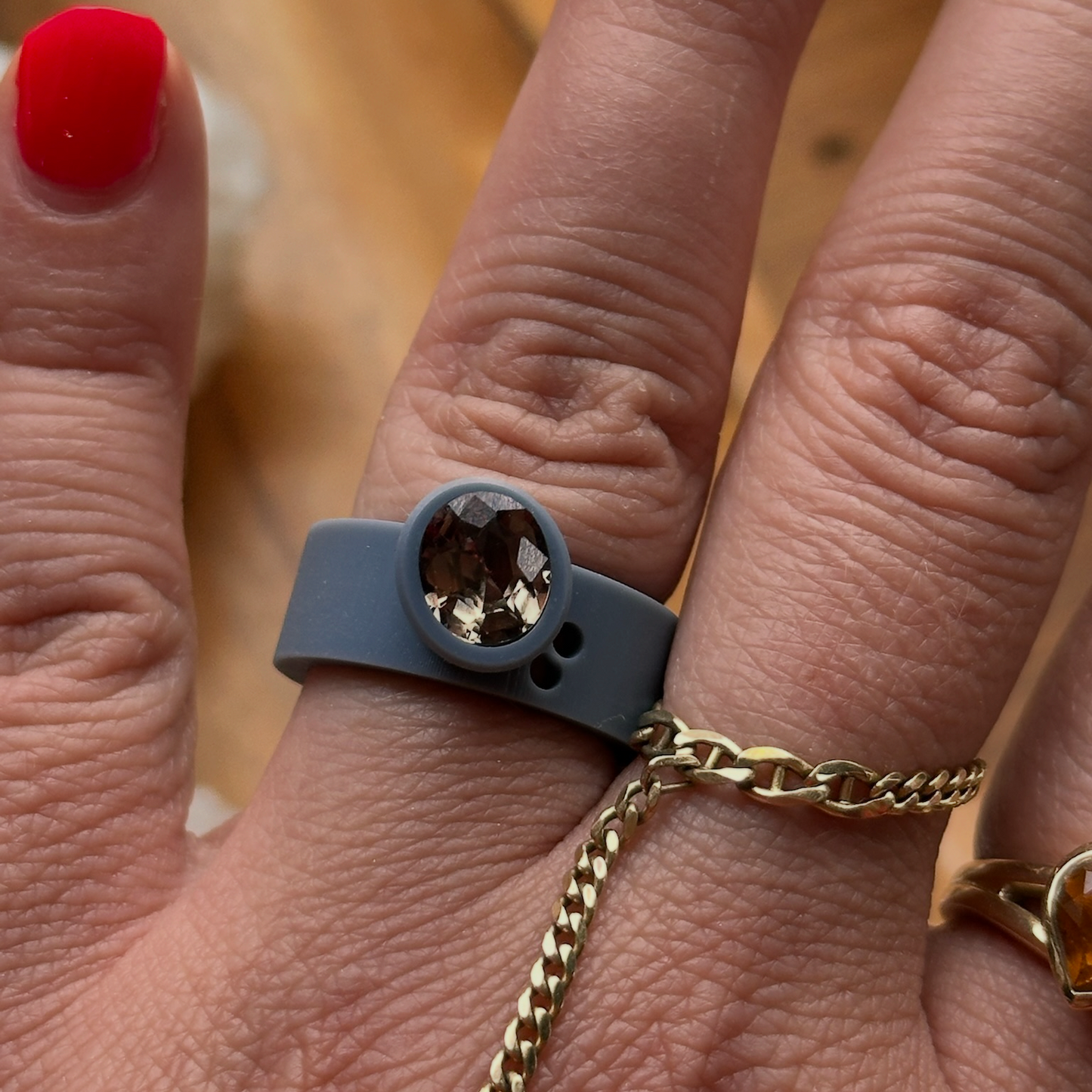 Close-up of a hand wearing a custom engagement ring in the production phase with a brown Montana sapphire center stone