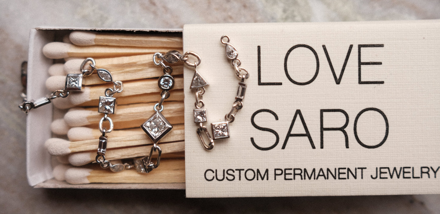 mixed shaped tennis bracelet with white diamonds displayed on a love saro matchbox